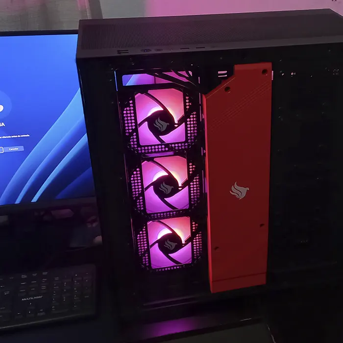 Montagem de PC gamer com gabinete preto, três ventoinhas frontais com iluminação RGB rosa e painel vermelho
